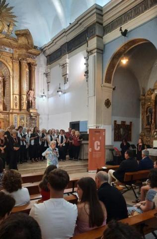 Carme Valls dirigint els tres cors i el públic
